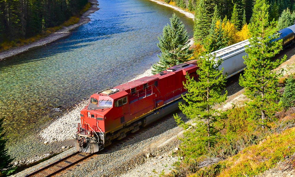 Freight train with cargo moving through mountains